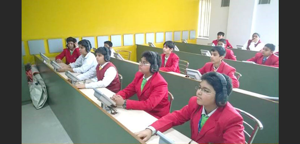 top school in rohini,the students are sitting in lab and using headphones
